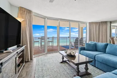 a living room with a blue couch and a television at The Perfect Escape! Long Beach Resort-8th Floor-Gulf Front with AMAZING views in Panama City Beach