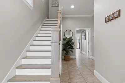a staircase in a house with a potted plant at Walk To The Beach! 3 Story Home! 2 Balconies With Gulf Views! in Panama City Beach