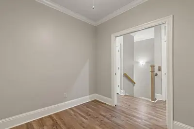 an empty living room with white walls and wood floors at Walk To The Beach! 3 Story Home! 2 Balconies With Gulf Views! in Panama City Beach