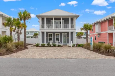 a house with palm trees in front of it at Fabulous Modern Beach House - 4BR, 35BA: POOL/Beach View & Access/Balcony in Panama City Beach