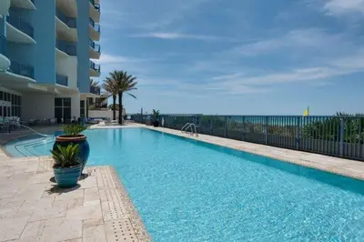 a large blue swimming pool next to a building at Sterling Breeze 1105 in Panama City Beach