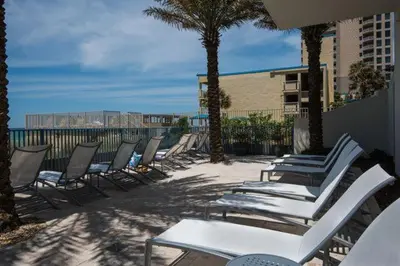 a row of chairs and tables on a beach at Sterling Breeze 1105 in Panama City Beach