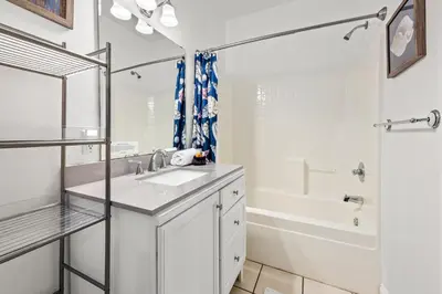 a white bathroom with a sink and a shower at Next To Pier Park! STEPS from the Beach! Dog-Friendly! Pool! in Panama City Beach