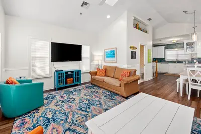 a living room with a couch and a tv at Next To Pier Park! STEPS from the Beach! Dog-Friendly! Pool! in Panama City Beach