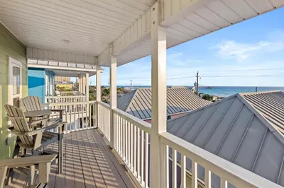 a porch with chairs and a view of the ocean at Next To Pier Park! STEPS from the Beach! Dog-Friendly! Pool! in Panama City Beach