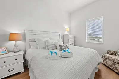 a bedroom with a white bed with two towels on it at Remarkably Updated 3/2 in Seagrove Highlands - Gulf Views Sleeps 9! in Santa Rosa Beach