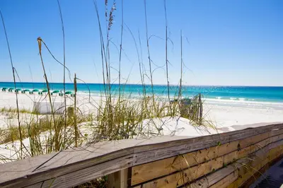 a beach with a wooden fence and the ocean at Remarkably Updated 3/2 in Seagrove Highlands - Gulf Views Sleeps 9! in Santa Rosa Beach