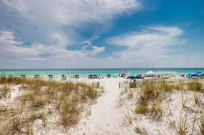 a beach with umbrellas and people on the beach at Remarkably Updated 3/2 in Seagrove Highlands - Gulf Views Sleeps 9! in Santa Rosa Beach