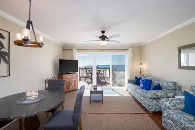 a living room with a couch and a table at Directly On The Beach! First Floor Sundeck! Near Pier Park! Sleeps 6! in Panama City Beach