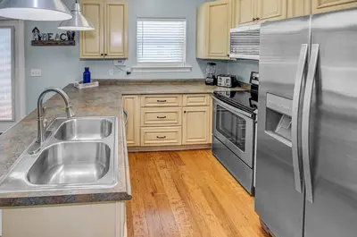 a kitchen with a stainless steel refrigerator and a sink at 5 Bed, 5 Bath Beach Home/Only a 3 Minute Walk To The Beach! SLEEPS 12 in Panama City Beach