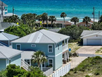 a blue house with the beach in the background at 5 Bed, 5 Bath Beach Home/Only a 3 Minute Walk To The Beach! SLEEPS 12 in Panama City Beach