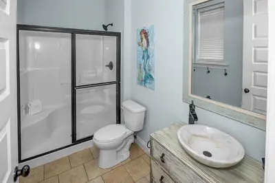a bathroom with a toilet and a shower and a sink at 5 Bed, 5 Bath Beach Home/Only a 3 Minute Walk To The Beach! SLEEPS 12 in Panama City Beach