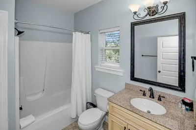 a bathroom with a toilet and a sink and a mirror at 5 Bed, 5 Bath Beach Home/Only a 3 Minute Walk To The Beach! SLEEPS 12 in Panama City Beach
