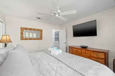 a bedroom with a bed and a flat screen tv at Contemporary Bungalow / West End PCB / Available NOW! / Perfect for Family in Panama City Beach
