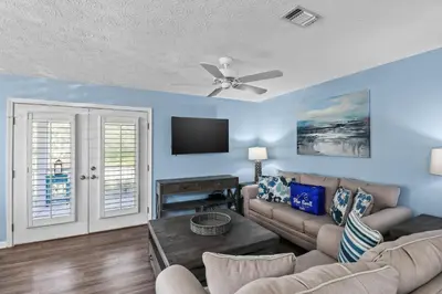 a living room with a couch and a ceiling fan at Contemporary Bungalow / West End PCB / Available NOW! / Perfect for Family in Panama City Beach