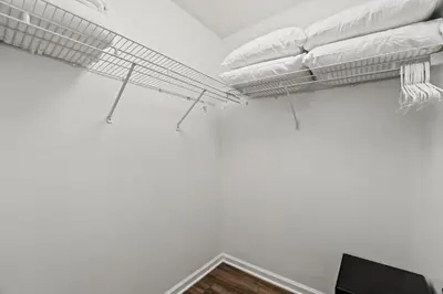a room with white walls and a tv and a shelf at Contemporary Bungalow / West End PCB / Available NOW! / Perfect for Family in Panama City Beach