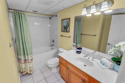 a bathroom with a sink and a toilet and a shower at Emerald Beach Resort Condo-Gulf Front+Beach Access! Beach Chair Service! in Panama City Beach