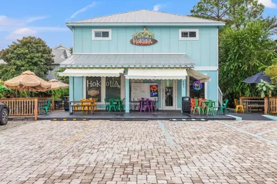 a blue building with tables and chairs in front of it at One Upon A Tide - Private Pool - Mother-In-Law Suite in Santa Rosa Beach