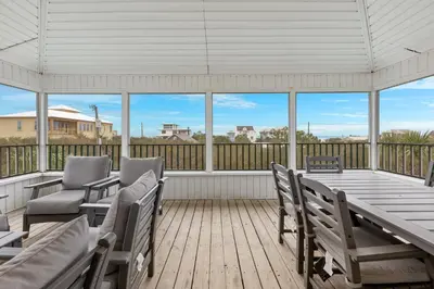 a screened in porch with a table and chairs at One Upon A Tide - Private Pool - Mother-In-Law Suite in Santa Rosa Beach