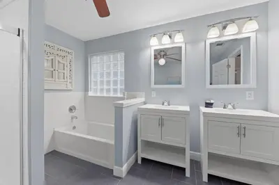 a white bathroom with two sinks and a bath tub and a mirror at One Upon A Tide - Private Pool - Mother-In-Law Suite in Santa Rosa Beach