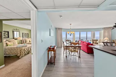a living room with a couch and a dining room at Gulf Front Living Room AND Master Suite! SLEEPS 8! in Panama City Beach