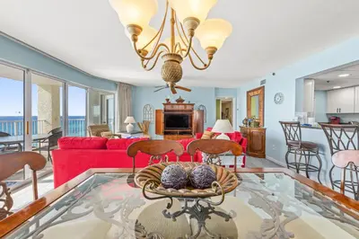 a living room with a red couch and a table at Gulf Front Living Room AND Master Suite! SLEEPS 8! in Panama City Beach