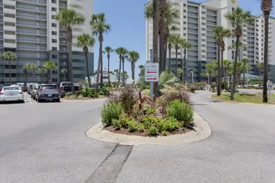 a street with a parking lot with palm trees at Gulf Front Living Room AND Master Suite! SLEEPS 8! in Panama City Beach