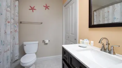 a bathroom with a toilet and a sink at Beautiful Townhome Right On The Gulf - Get Ready To Relax! in Panama City Beach