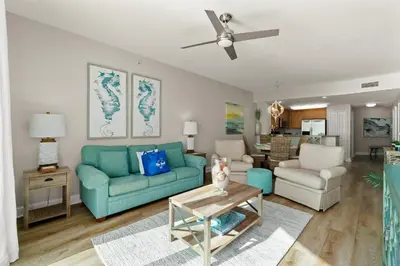 a living room with a blue couch and chairs at Aqua Resort 2108 - Beach Daze in Panama City Beach