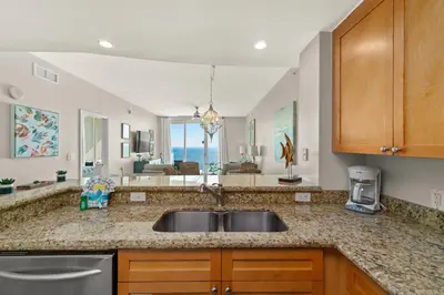 a kitchen with a sink and a view of the ocean at Aqua Resort 2108 - Beach Daze in Panama City Beach