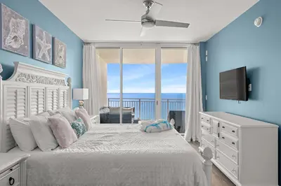 a bedroom with a white bed with a view of the ocean at Aqua Resort 2108 - Beach Daze in Panama City Beach