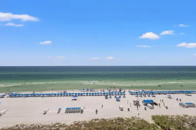 a group of people on a beach with the ocean at Emerald Beach Resort by Blue Swell in Panama City Beach