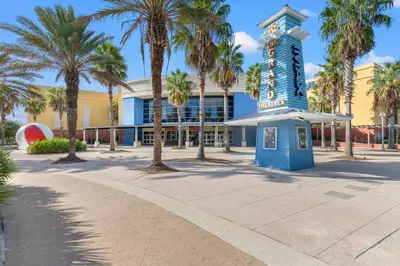 a building with palm trees and a blue tower at Quaint 2BR/25BA Cottage Nestled Between 30A & Panama City Beach! Sleeps 6! in Panama City Beach