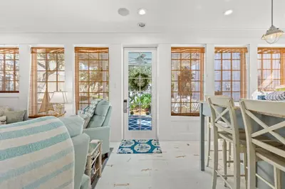 a living room with white walls and windows at Quaint 2BR/25BA Cottage Nestled Between 30A & Panama City Beach! Sleeps 6! in Panama City Beach