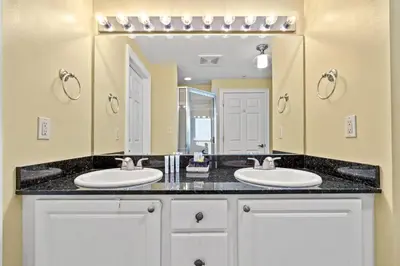a bathroom with two sinks and a large mirror at Beautiful 3rd Floor Condo w Gulf Front Master - Near Pier Park in Panama City Beach