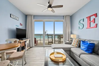 a living room with a couch and a table at Beautiful 3rd Floor Condo w Gulf Front Master - Near Pier Park in Panama City Beach