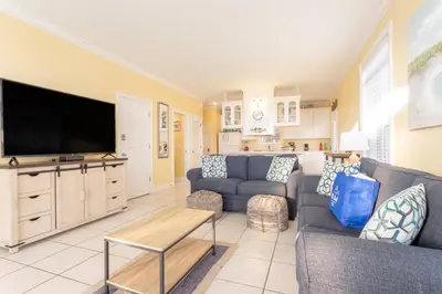 a living room with a couch and a flat screen tv at Across Street from Beach - Close to Pier Park - Sleeps 6! in Panama City Beach