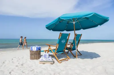 a pair of chairs and an umbrella on the beach at Luxury Gulf Front Property! Directly on the Beach! Sleeps 15! in Panama City Beach