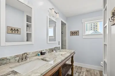 a bathroom with a sink and two mirrors at Luxury Gulf Front Property! Directly on the Beach! Sleeps 15! in Panama City Beach