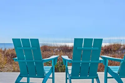 two blue chairs sitting next to the beach at Luxury Gulf Front Property! Directly on the Beach! Sleeps 15! in Panama City Beach