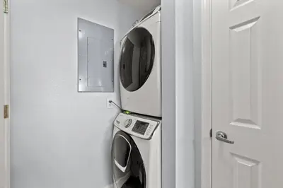 a washer and dryer in a room with a door at Tidewater Beach Luxury Penthouse with Resort Amenities and a View! in Panama City Beach