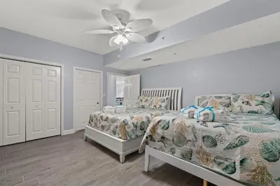 a bedroom with a bed and a ceiling fan at Tidewater Beach Luxury Penthouse with Resort Amenities and a View! in Panama City Beach