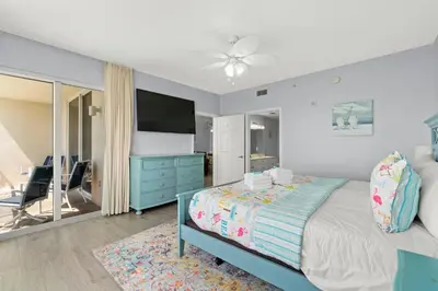 a bedroom with a bed and a blue dresser at Tidewater Beach Luxury Penthouse with Resort Amenities and a View! in Panama City Beach