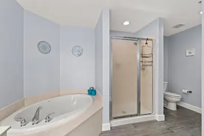 a white bathroom with a tub and a toilet at Tidewater Beach Luxury Penthouse with Resort Amenities and a View! in Panama City Beach