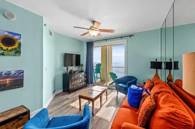 a living room with a couch and chairs and a tv at Come See Why This Is The Best Condo At Grand Panama! Rooftop Pool+Tiki Bar in Panama City Beach