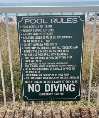 a sign on a fence that says no driving at Come See Why This Is The Best Condo At Grand Panama! Rooftop Pool+Tiki Bar in Panama City Beach