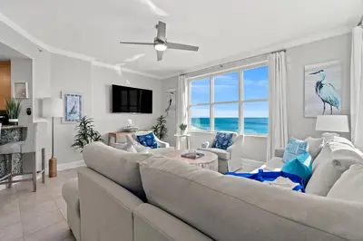 a living room with a couch and a large window at Luxury Beachfront Condo w/ 2 Balconies! Sleeps 8! Walk to Pier Park! in Panama City Beach