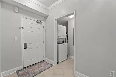 a hallway with a white door and a refrigerator at Luxury Beachfront Condo w/ 2 Balconies! Sleeps 8! Walk to Pier Park! in Panama City Beach