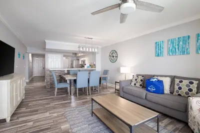 a living room with a couch and a table at Brand New Throughout! Emerald Beach - Gulf Front! Sleeps 8! in Panama City Beach