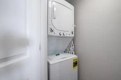 a bathroom with a sink and a mirror over a toilet at Brand New Throughout! Emerald Beach - Gulf Front! Sleeps 8! in Panama City Beach